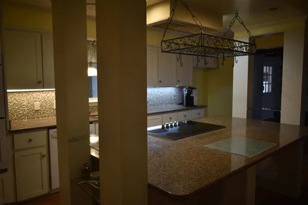 a bathroom with a sink a light fixture and a glass door