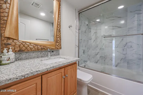 a bathroom with a granite countertop sink toilet and shower