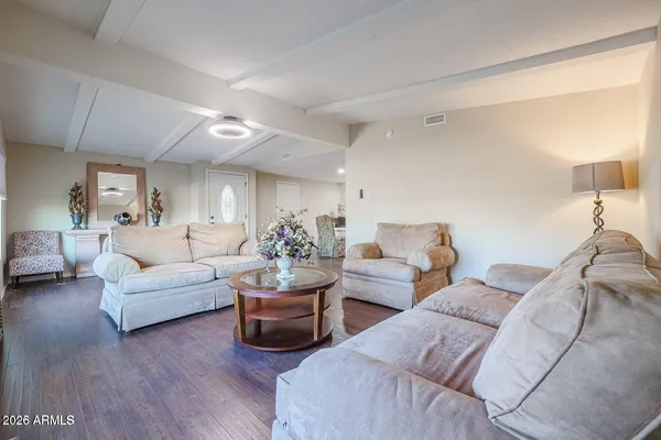 a living room with furniture and a wooden floor