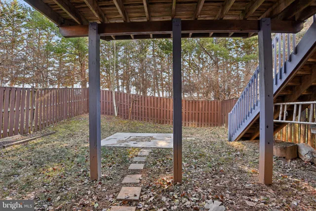 a view of a yard with porch and wooden fence