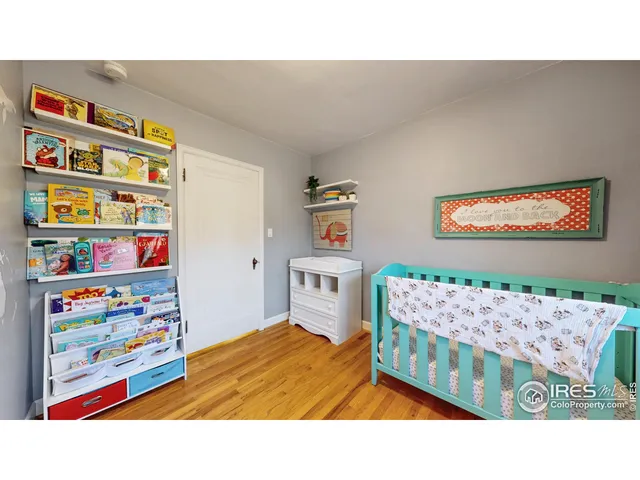 a bedroom with a bed and painting on the wall