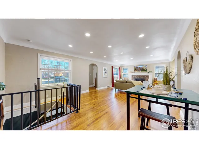 a living room with stainless steel appliances wooden floor dining table chairs and wooden floor