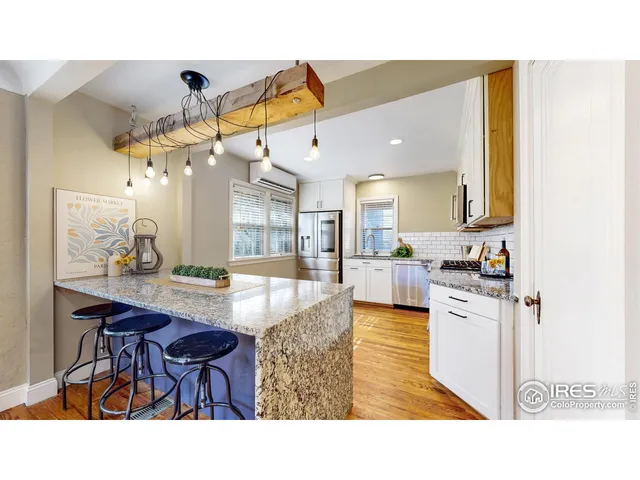 a kitchen with stainless steel appliances kitchen island granite countertop a table and chairs in it