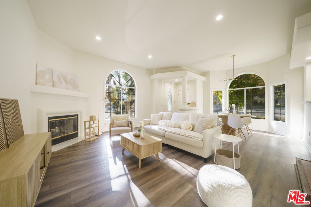 a living room with furniture a fireplace and a floor to ceiling window