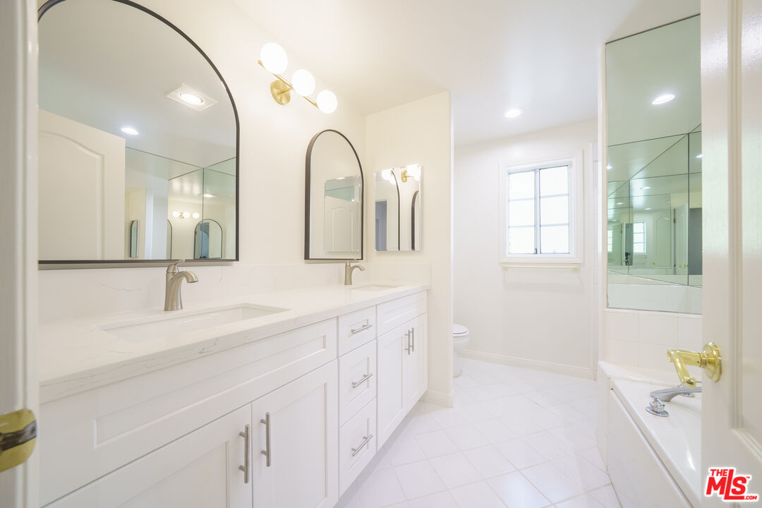 4520 Pennsylvania Avenue, Unit 119 La Crescenta, CA 91214 - Photo 10 of 13 a spacious bathroom with a double vanity sink a mirror and a bathtub
