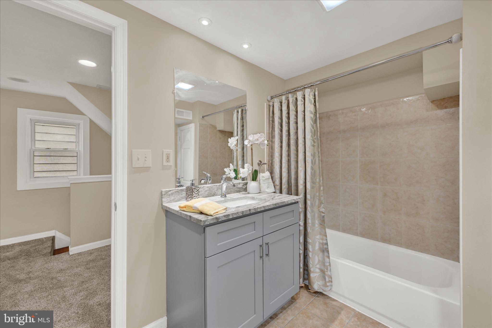 8511 Frederick Road Ellicott City, MD 21043 - Photo 20 of 36 a bathroom with a sink double vanity granite tub shower and a mirror