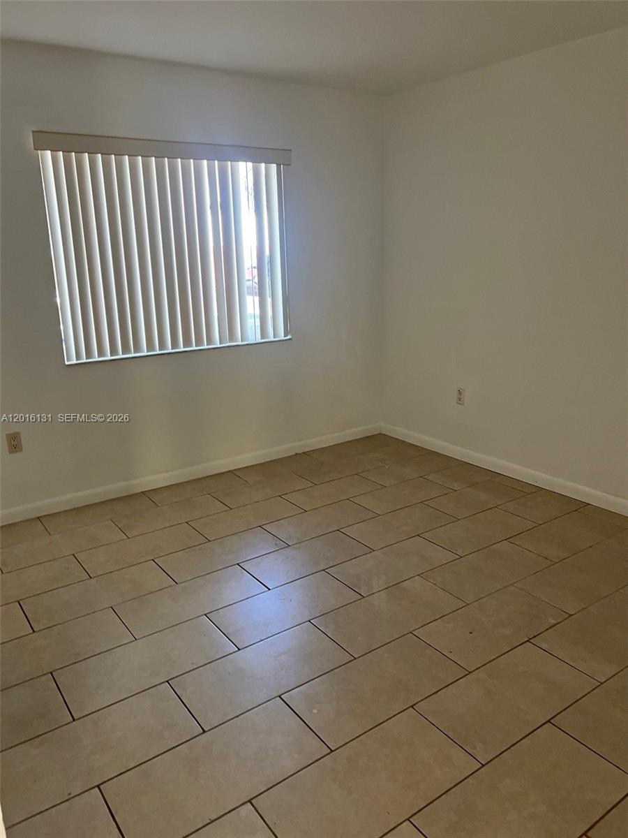 12605 Southwest 91st Street, Unit 103 Miami, FL 33186 - Photo 12 of 14 an empty room with windows