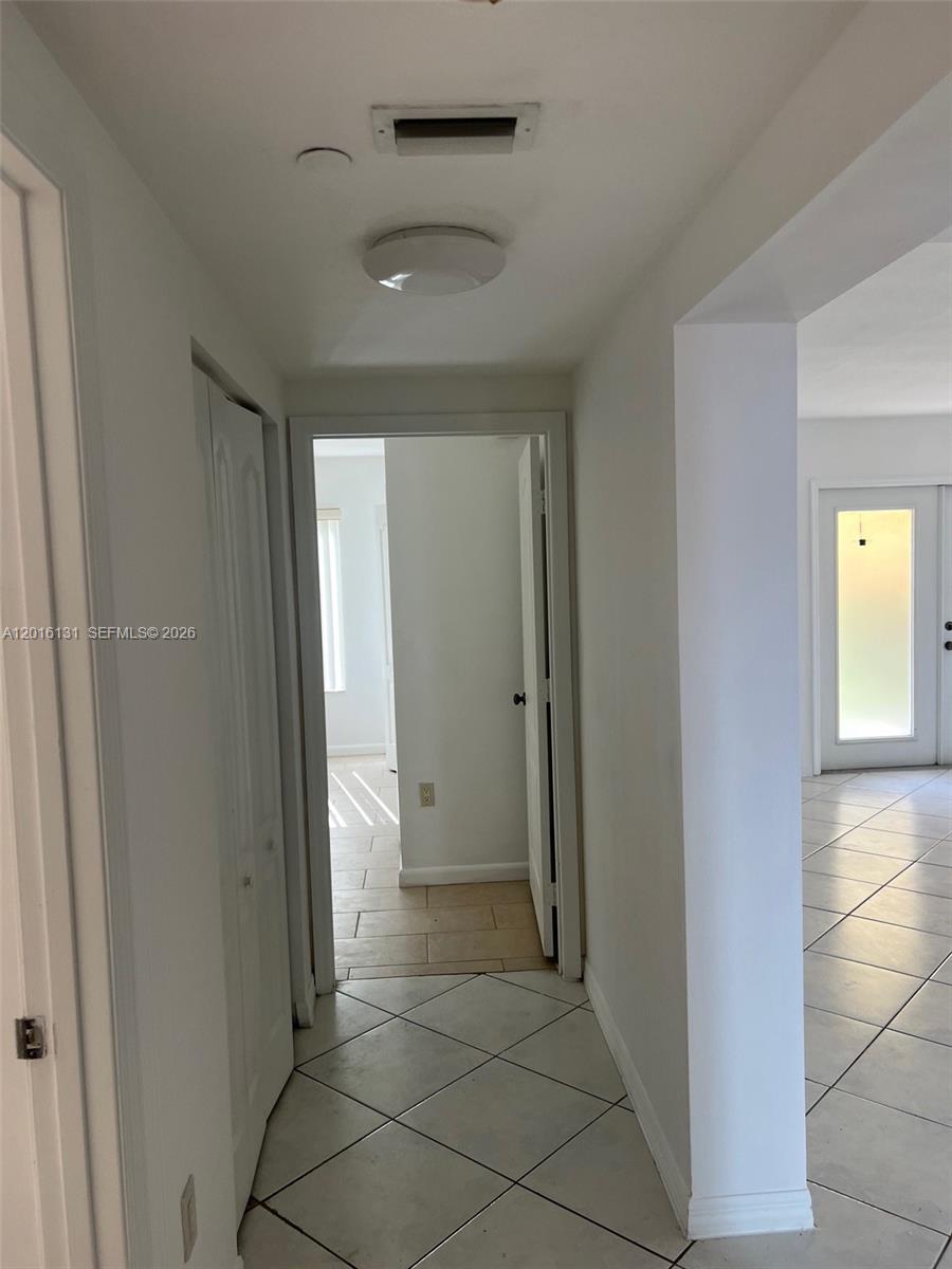 12605 Southwest 91st Street, Unit 103 Miami, FL 33186 - Photo 4 of 14 a view of a hallway with wooden floor and a bathroom
