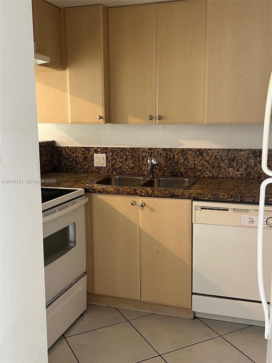 12605 Southwest 91st Street, Unit 103 Miami, FL 33186 - Photo 5 of 14 a kitchen with granite countertop white cabinets and white appliances