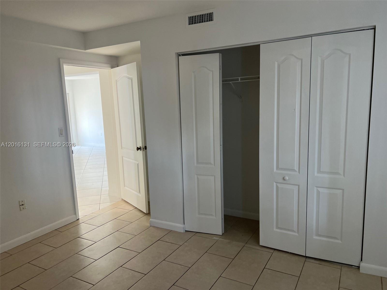 12605 Southwest 91st Street, Unit 103 Miami, FL 33186 - Photo 10 of 14 an empty room with wooden door