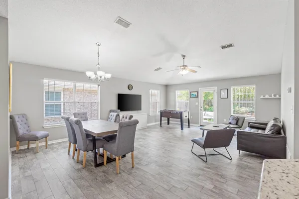 a living room with lots of furniture and chandelier