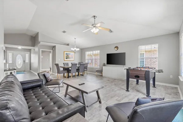a view of a dining room with furniture a chandelier and wooden floor
