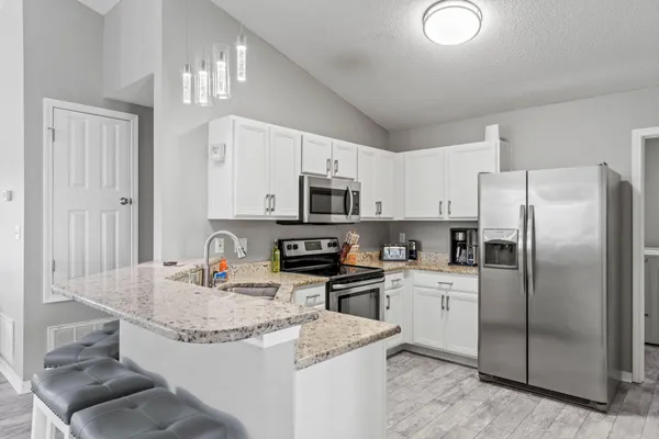 a kitchen with stainless steel appliances granite countertop a stove microwave and cabinets