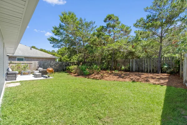 a view of a backyard with table and chairs under an umbrella