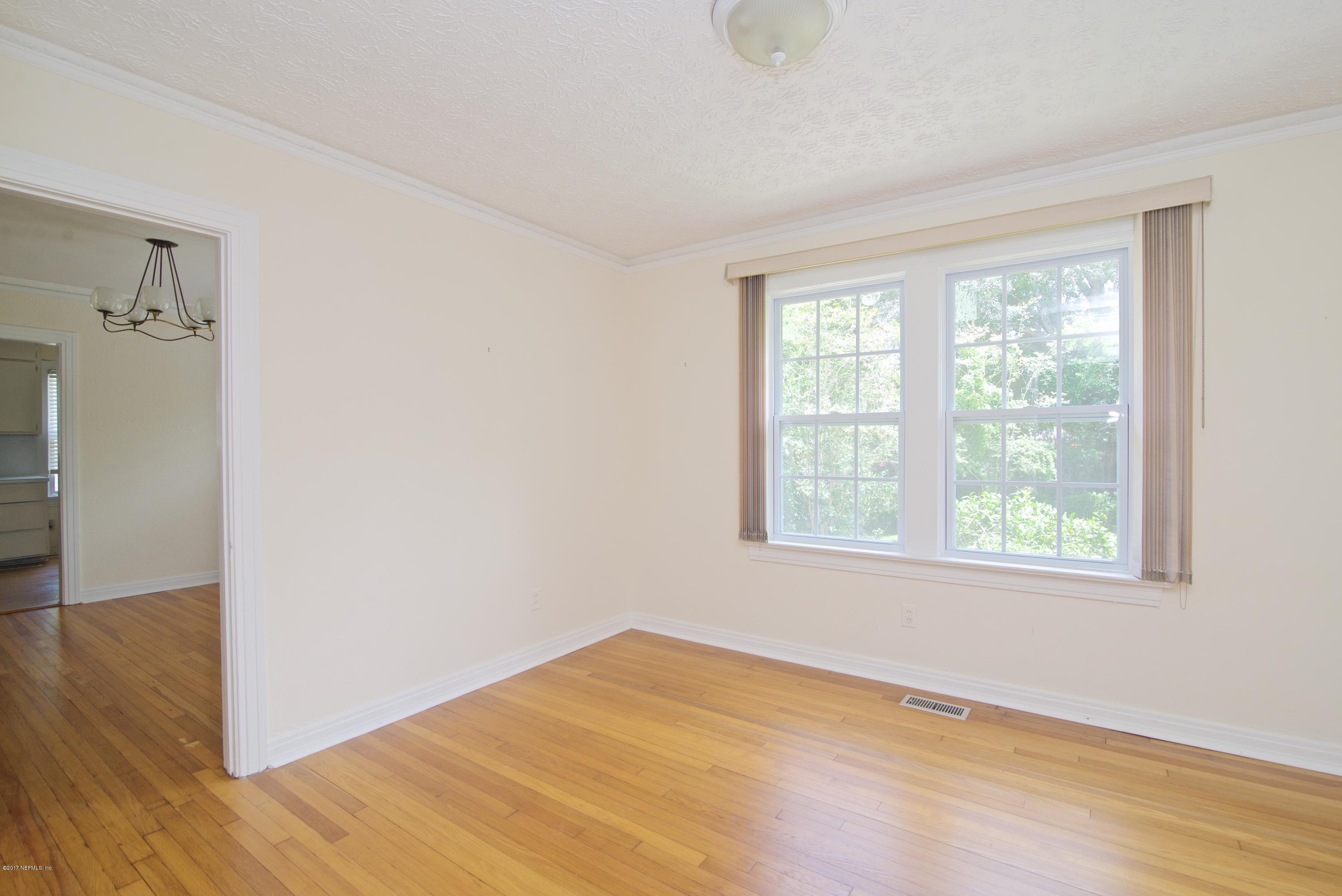 3877 Gadsden Road Jacksonville, FL 32207 - Photo 12 of 24 a view of an empty room with wooden floor and a window