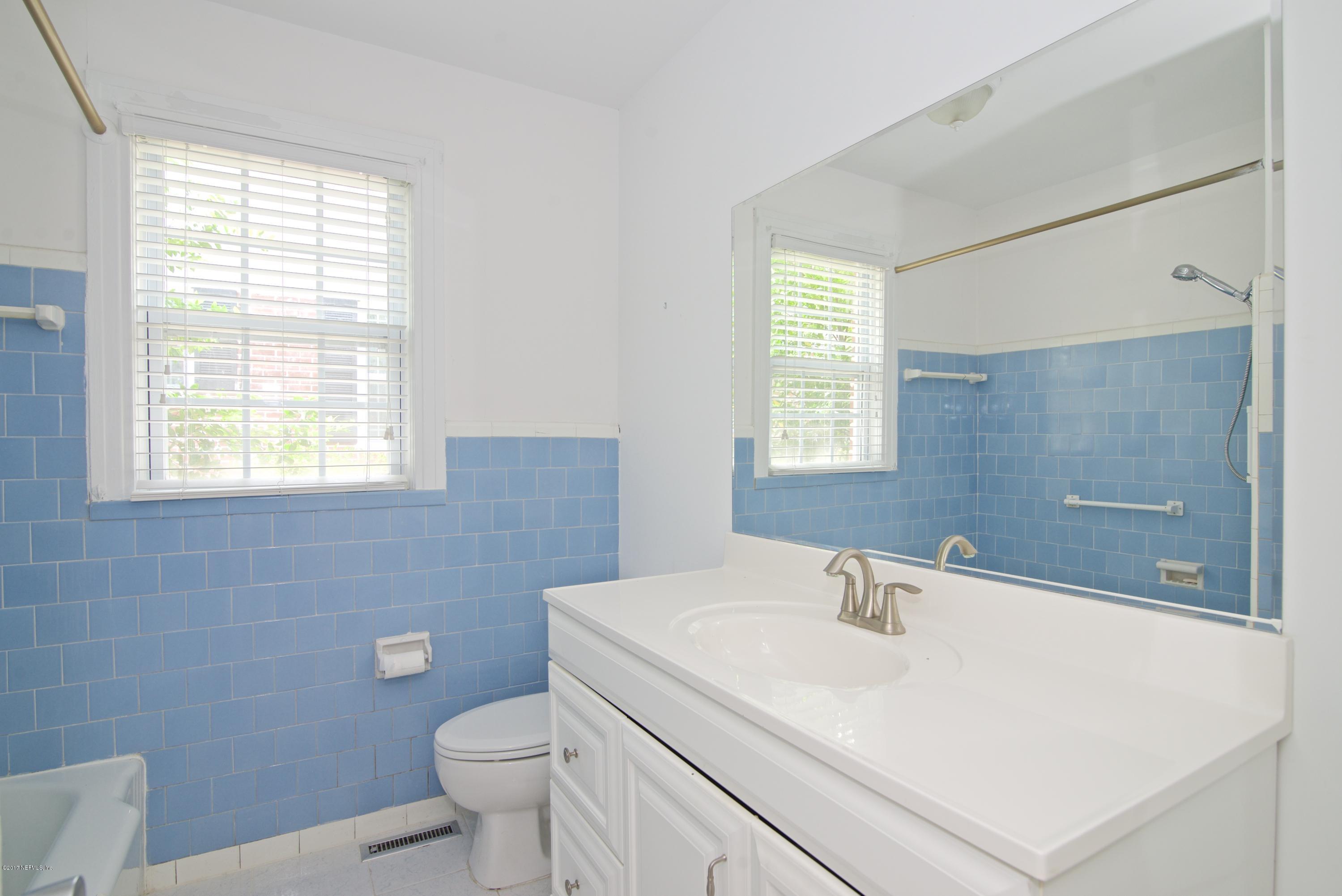3877 Gadsden Road Jacksonville, FL 32207 - Photo 15 of 24 a bathroom with a sink a toilet and window