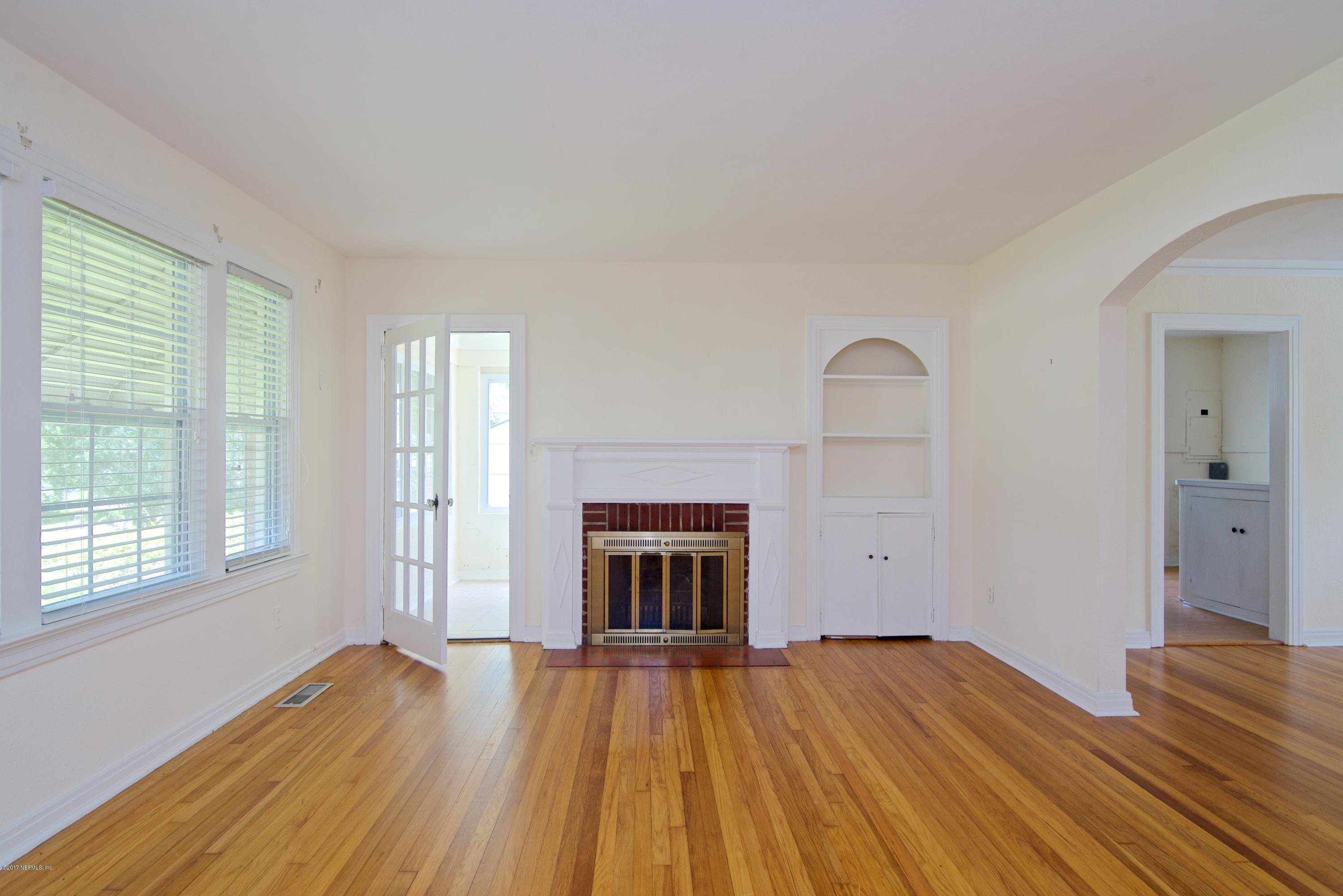 3877 Gadsden Road Jacksonville, FL 32207 - Photo 19 of 24 a view of an empty room with wooden floor fireplace and a window