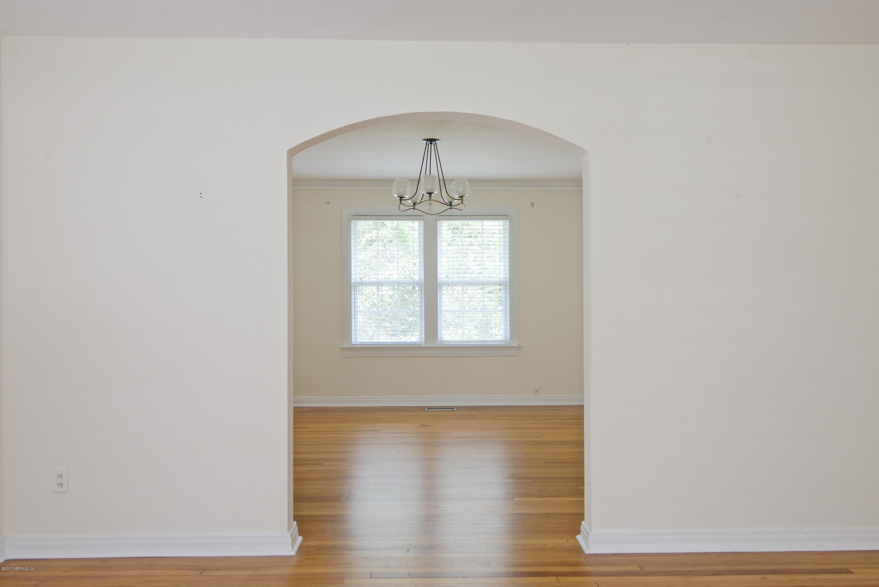 3877 Gadsden Road Jacksonville, FL 32207 - Photo 21 of 24 an empty room with wooden floor chandelier and windows