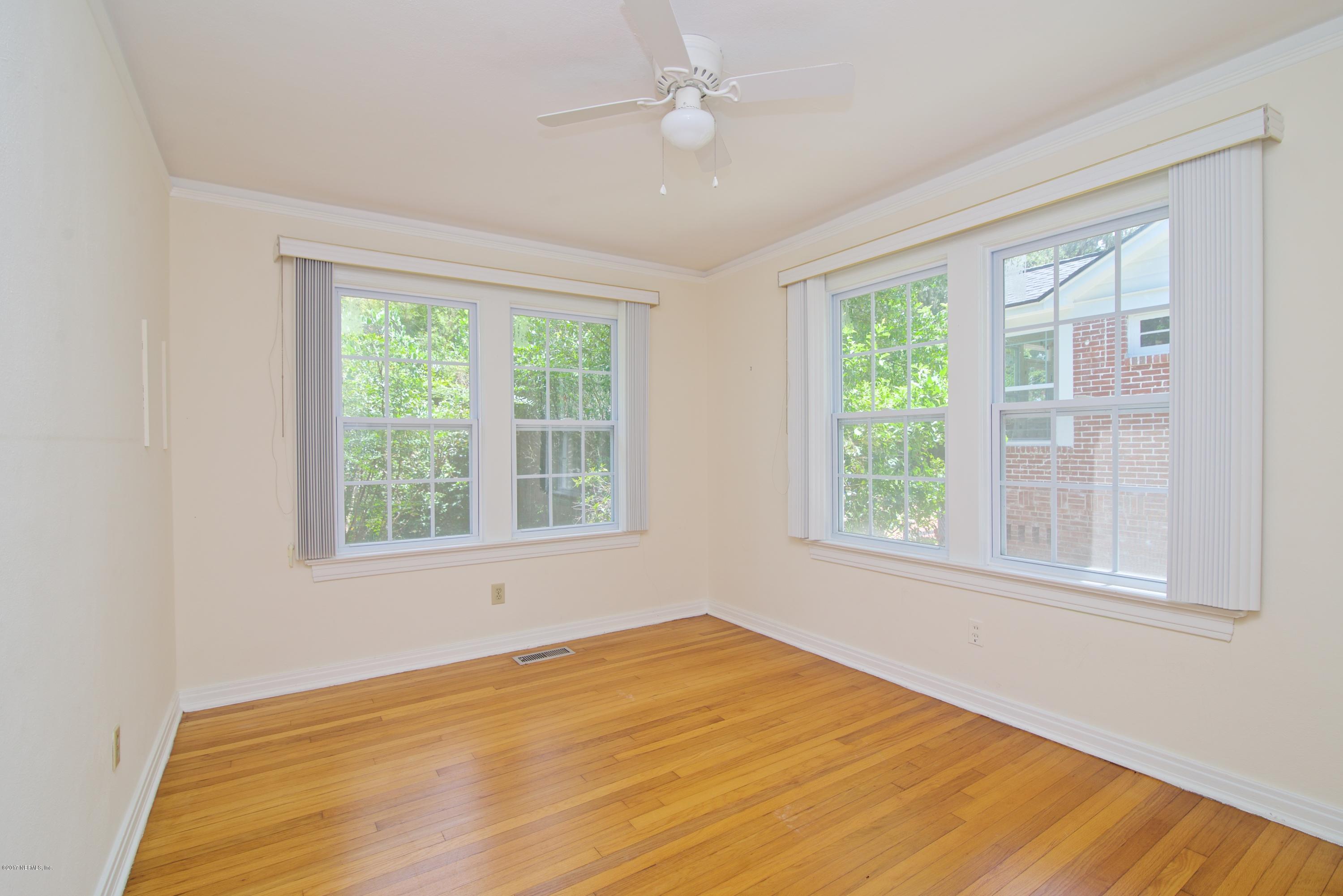 3877 Gadsden Road Jacksonville, FL 32207 - Photo 9 of 24 a view of an empty room with wooden floor and a window
