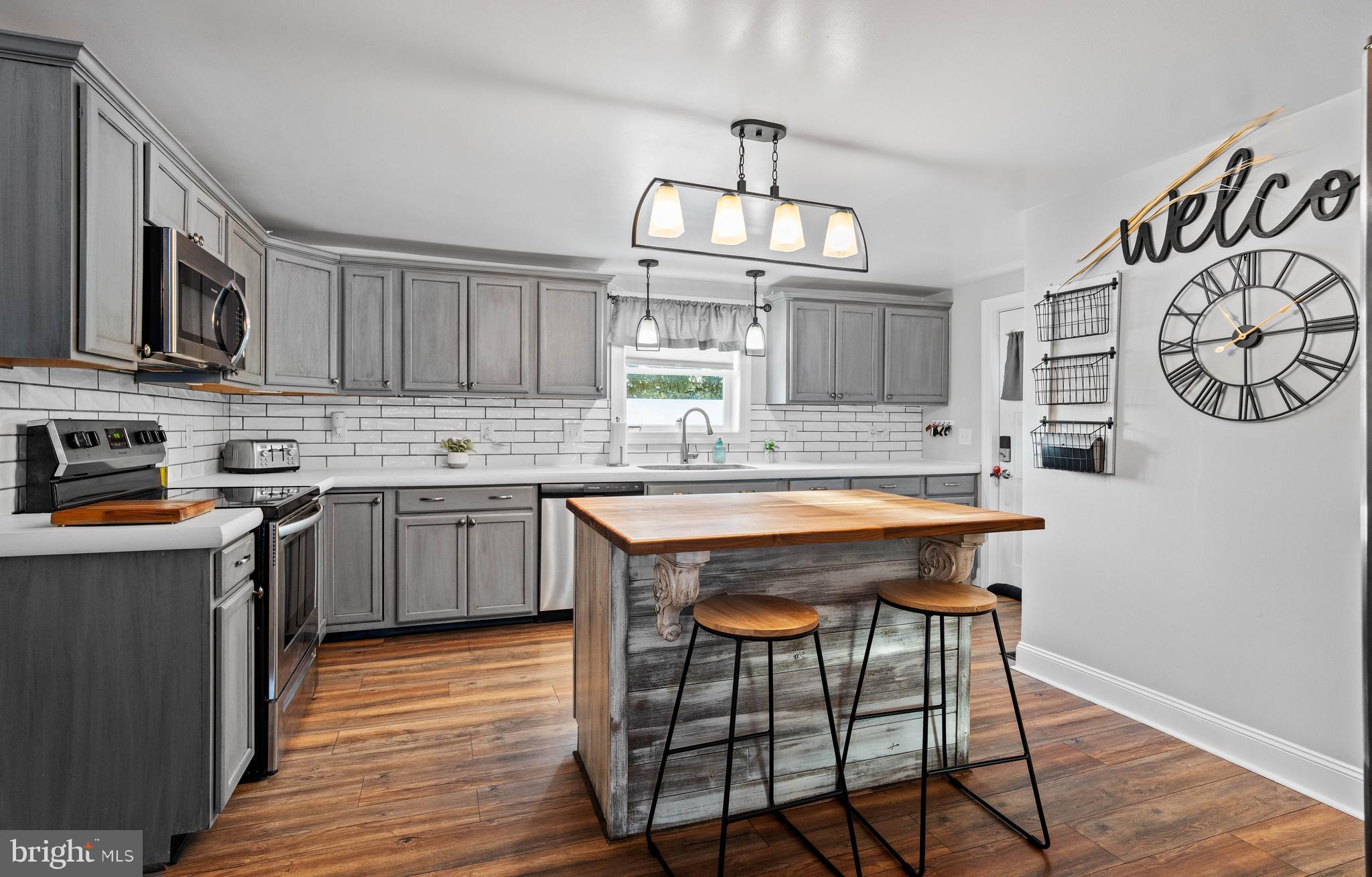 197 Ridge Street Smokerun, PA 16681 - Photo 3 of 47 a kitchen with stainless steel appliances granite countertop a stove a sink dishwasher a microwave oven with cabinets and wooden floor