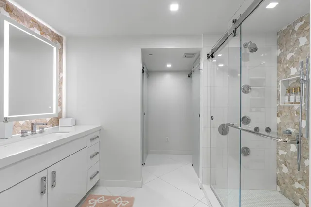 a bathroom with a shower sink vanity and mirror