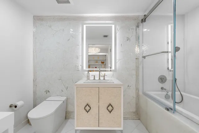 a bathroom with a granite countertop sink toilet and shower