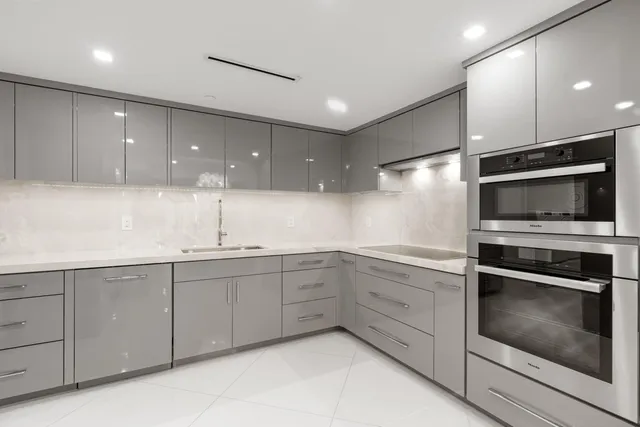 a kitchen with white cabinets stainless steel appliances and sink
