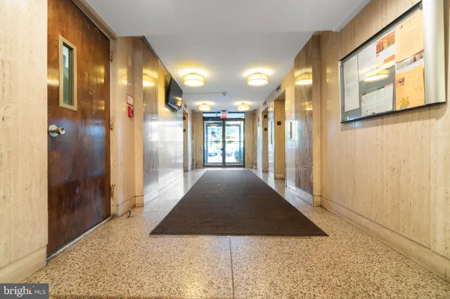 a living room with furniture and a dining table with kitchen appliances
