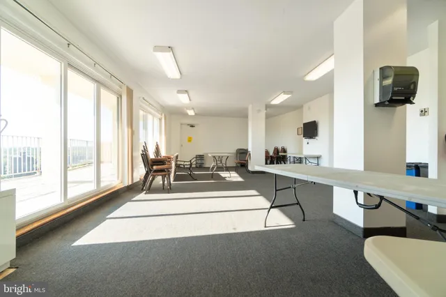 a living room with furniture and large windows