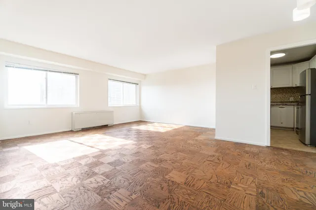 an empty room with windows and cabinet