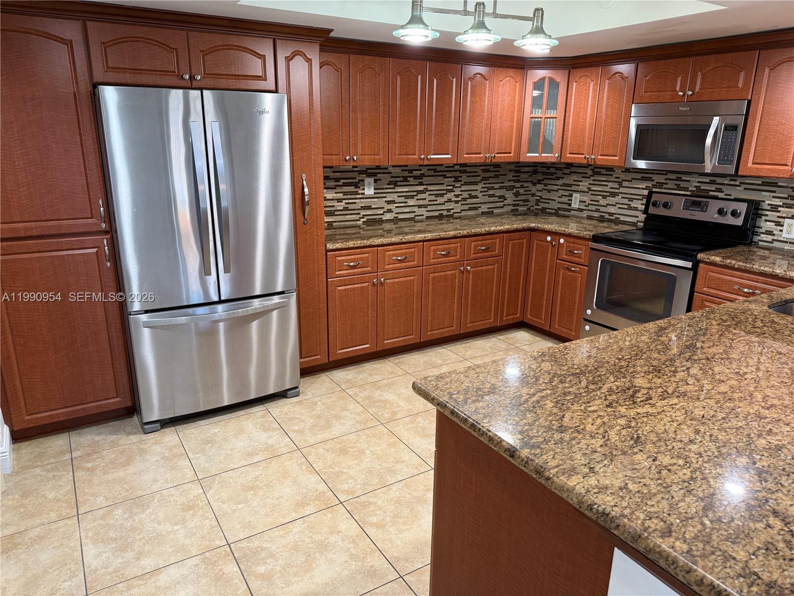4825 Southwest 149th Court, Unit 18B Miami, FL 33185 - Photo 11 of 36 a kitchen with stainless steel appliances granite countertop a sink stove and refrigerator