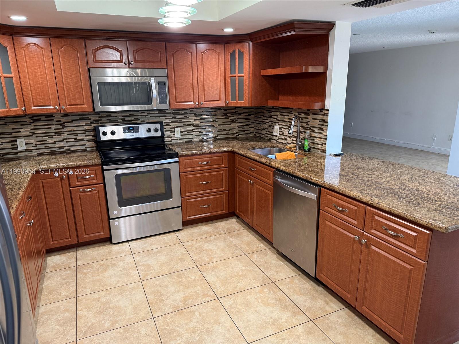 4825 Southwest 149th Court, Unit 18B Miami, FL 33185 - Photo 12 of 36 a kitchen with stainless steel appliances granite countertop a stove sink and cabinets