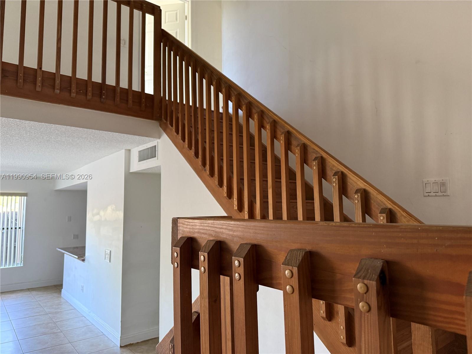 4825 Southwest 149th Court, Unit 18B Miami, FL 33185 - Photo 4 of 36 a view of staircase with railing and white walls