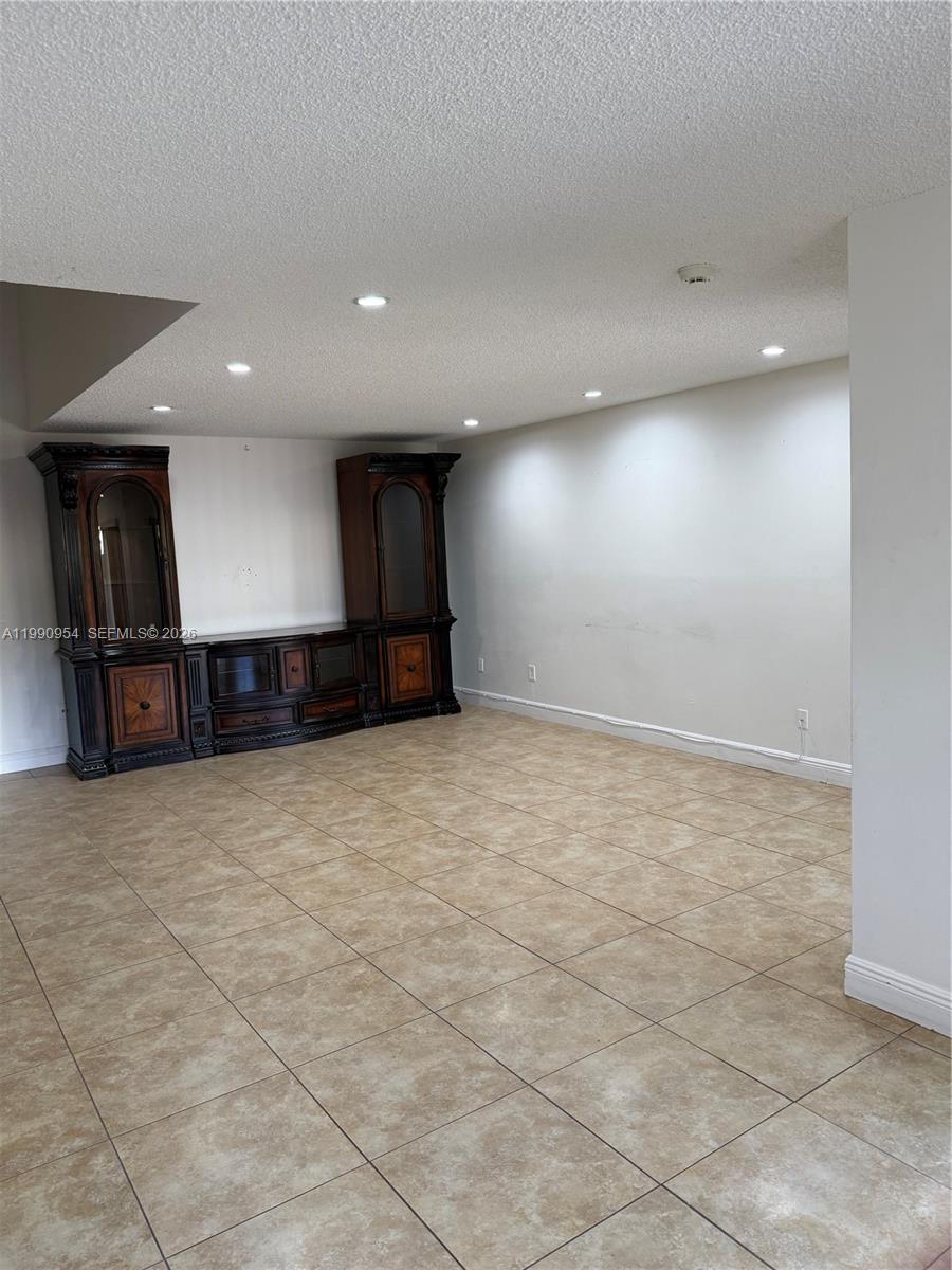 4825 Southwest 149th Court, Unit 18B Miami, FL 33185 - Photo 8 of 36 an empty room with wooden cabinet and windows
