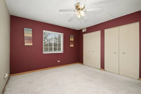 a view of an empty room with closet and a window
