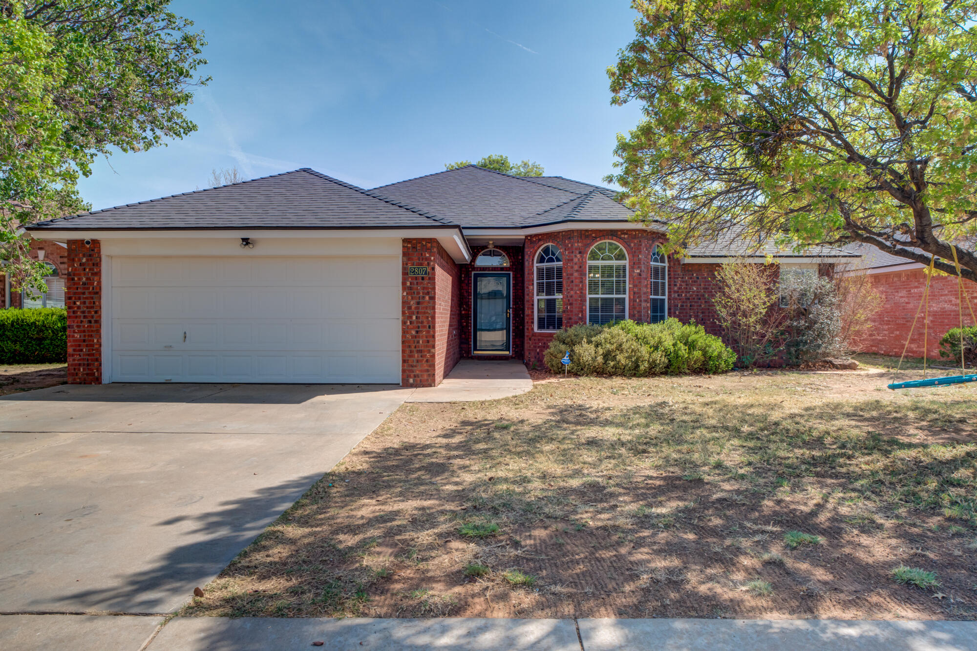 2807 87th Street Lubbock, TX 79423 - Photo 1 of 38 a front view of a house with a yard and garage