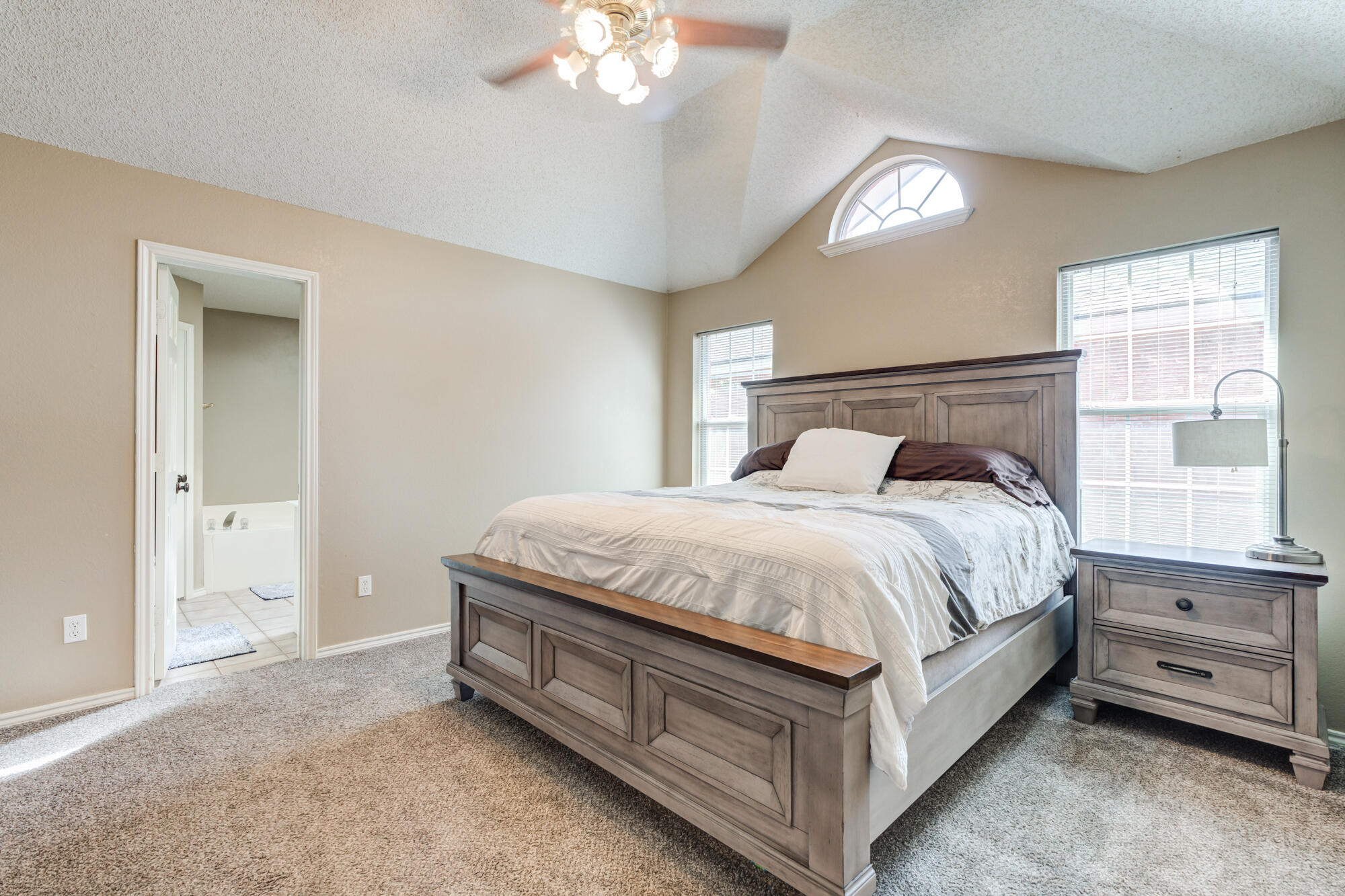 2807 87th Street Lubbock, TX 79423 - Photo 20 of 38 a spacious bedroom with a bed and a chandelier