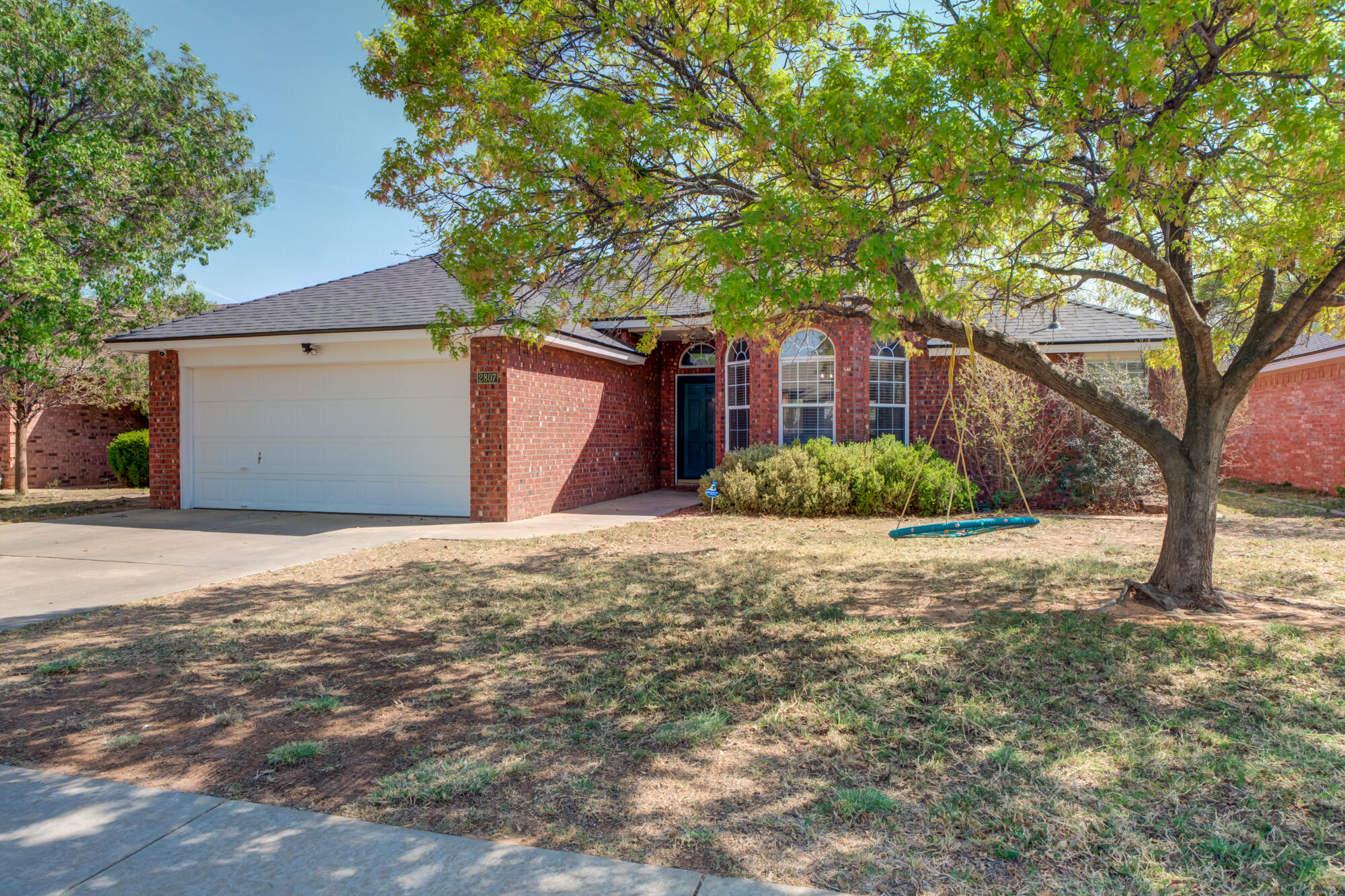 2807 87th Street Lubbock, TX 79423 - Photo 2 of 38 a front view of a house with a yard and garage