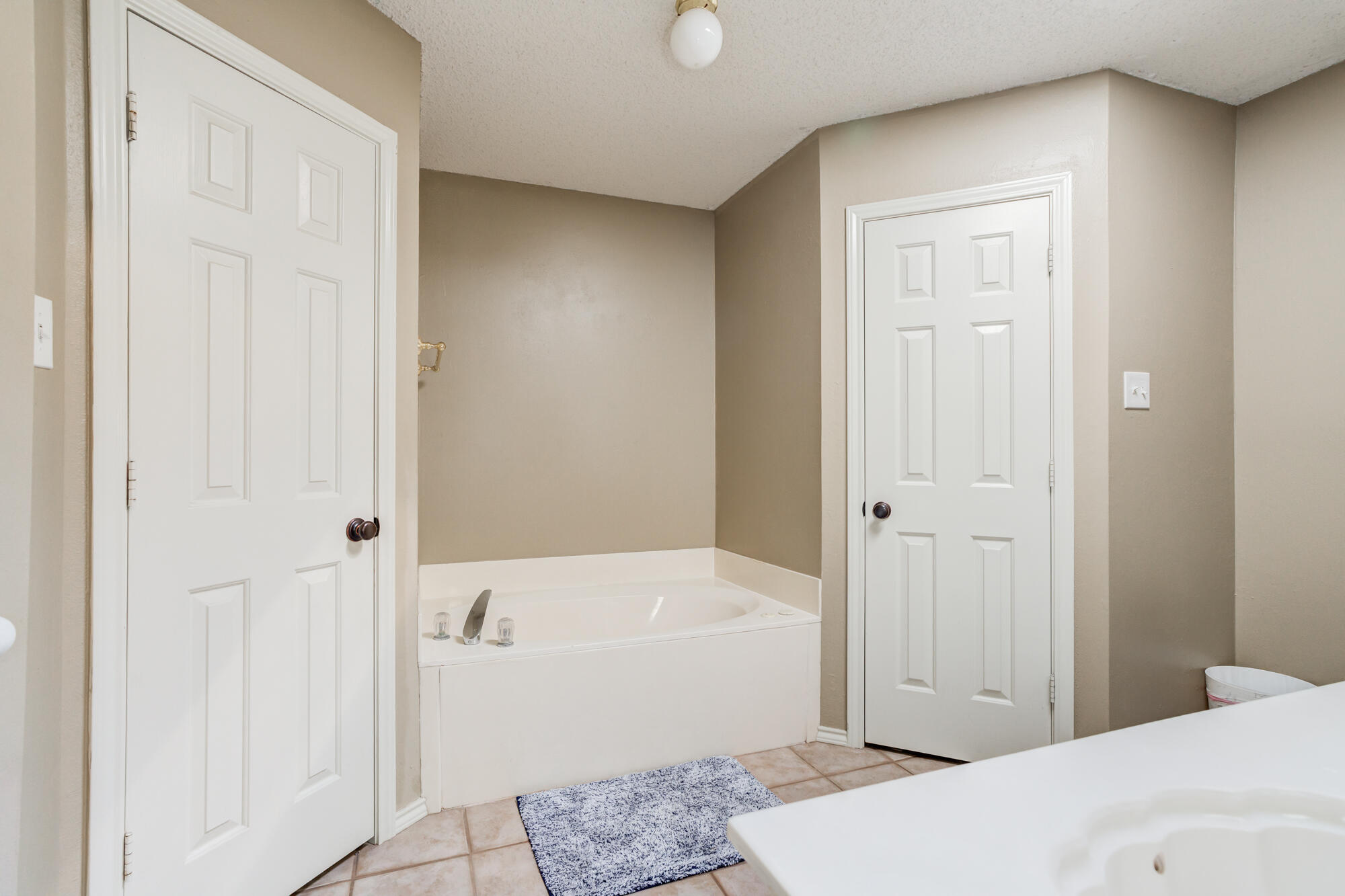 2807 87th Street Lubbock, TX 79423 - Photo 23 of 38 a bathroom with a tub shower and hallway