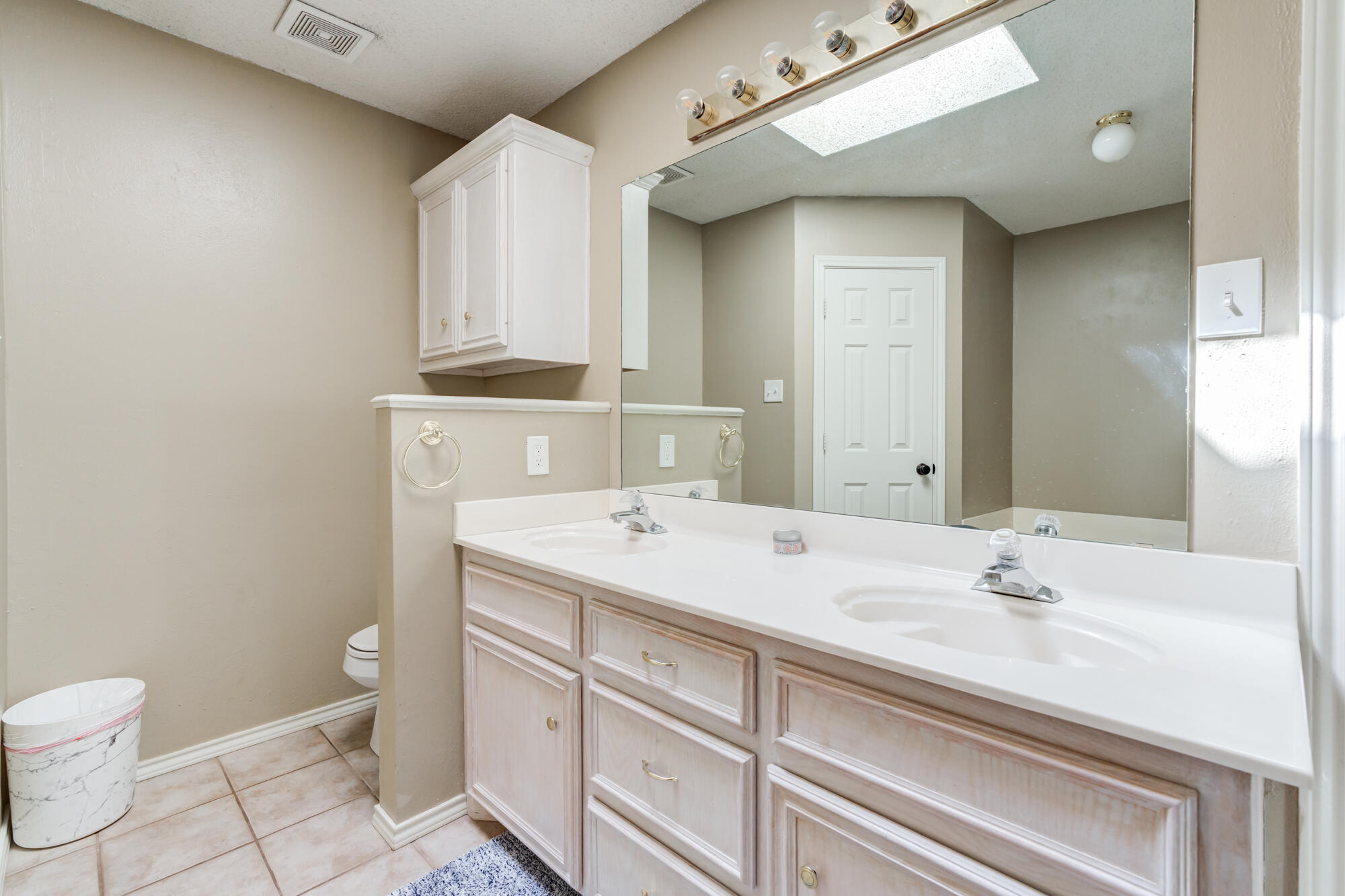 2807 87th Street Lubbock, TX 79423 - Photo 24 of 38 a bathroom with a sink a toilet and a mirror