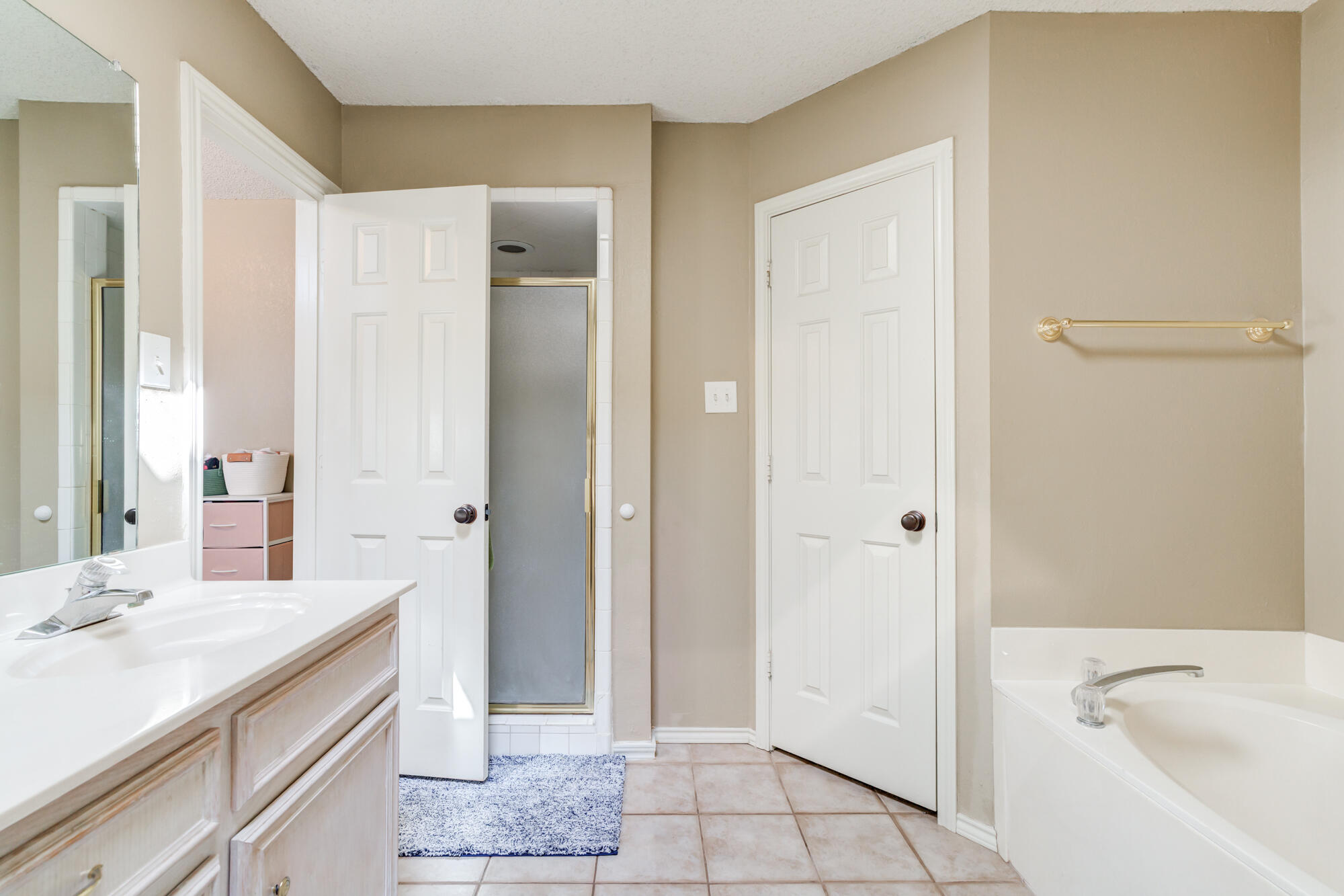 2807 87th Street Lubbock, TX 79423 - Photo 25 of 38 a spacious bathroom with a granite countertop sink a mirror and a bathtub