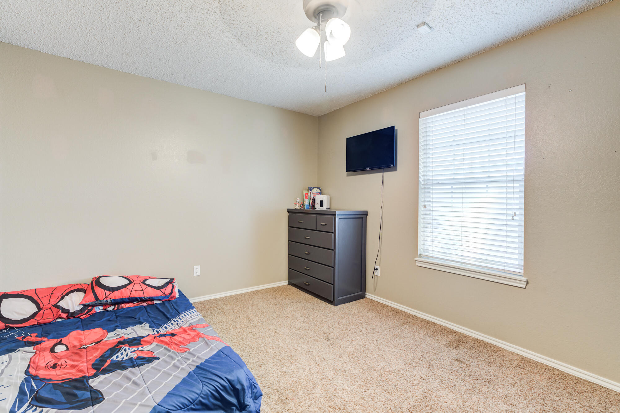 2807 87th Street Lubbock, TX 79423 - Photo 28 of 38 a bedroom with a bed and a chandelier