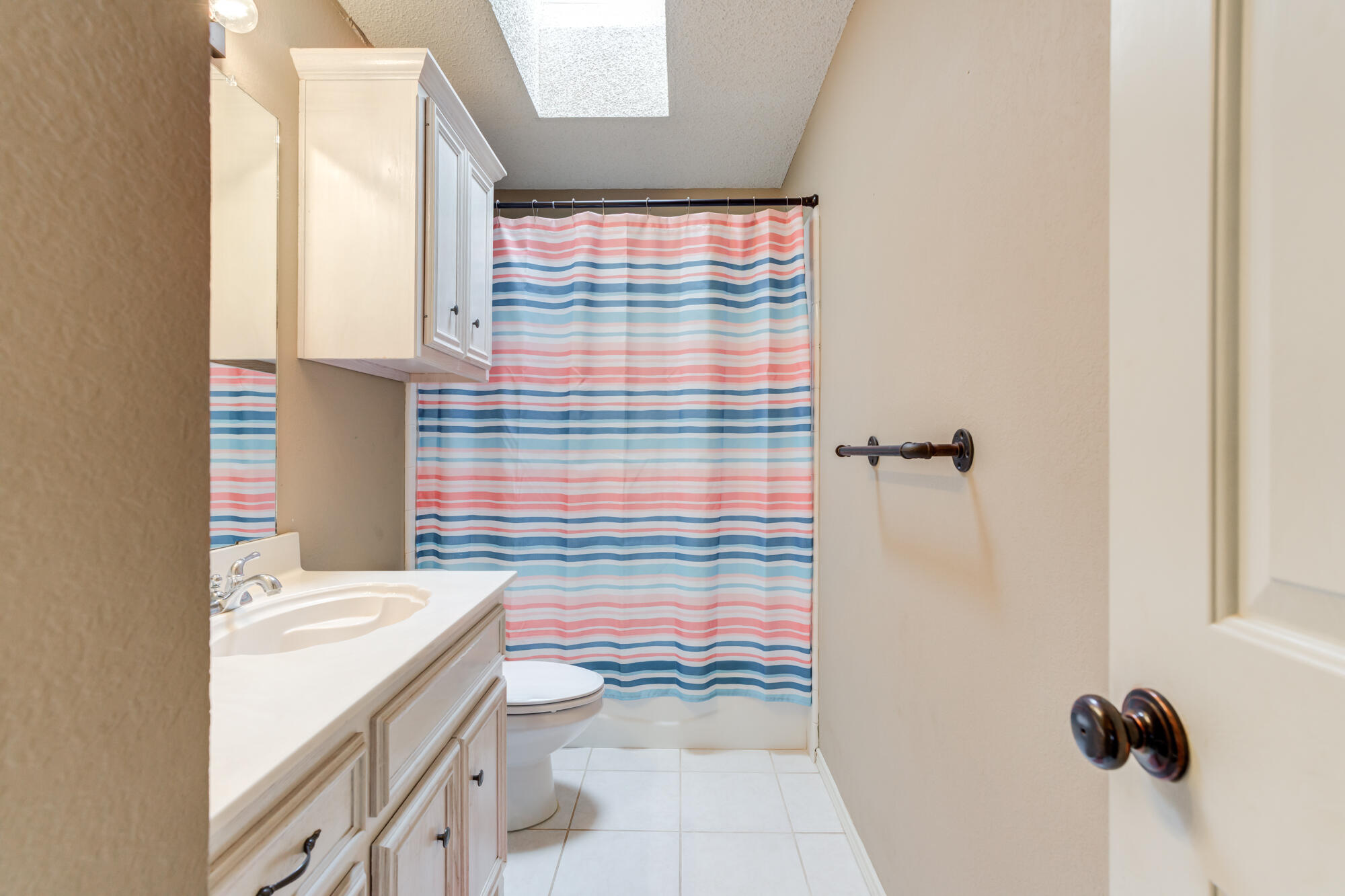 2807 87th Street Lubbock, TX 79423 - Photo 31 of 38 a bathroom with a granite countertop sink a toilet and shower