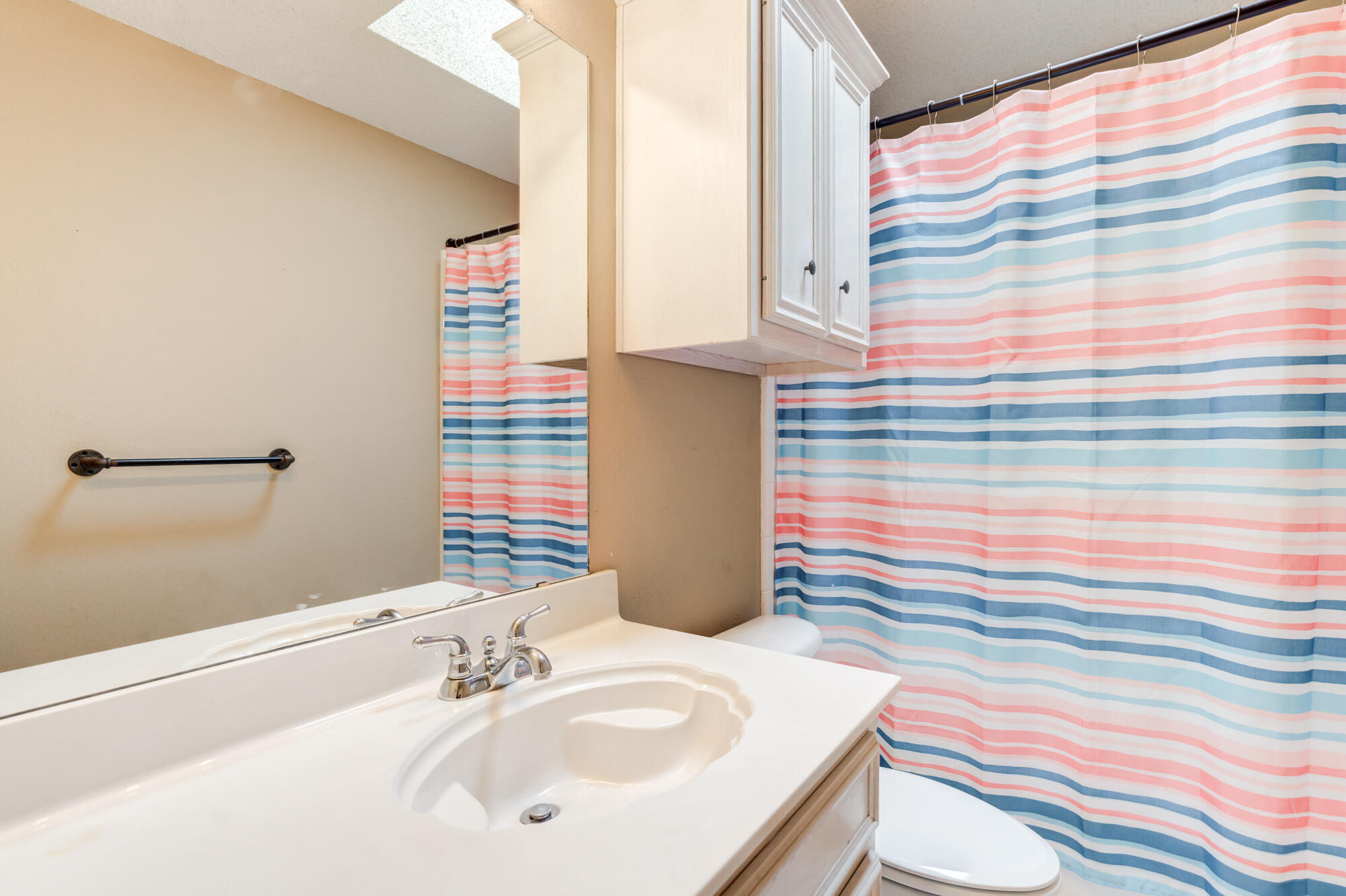 2807 87th Street Lubbock, TX 79423 - Photo 32 of 38 a bathroom with a sink a toilet and shower curtain