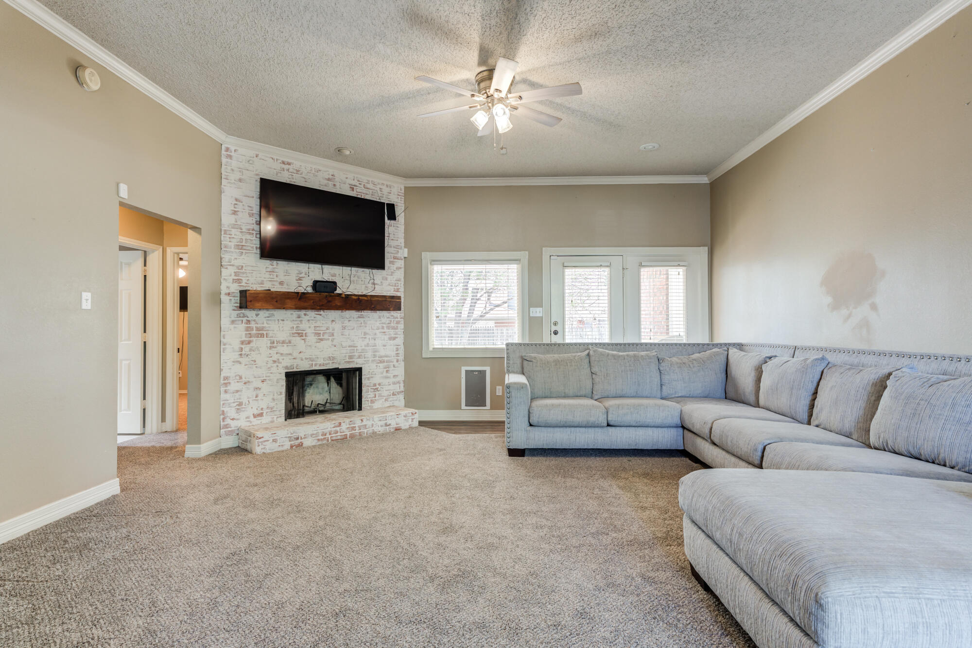 2807 87th Street Lubbock, TX 79423 - Photo 4 of 38 a living room with furniture a fireplace and a flat screen tv
