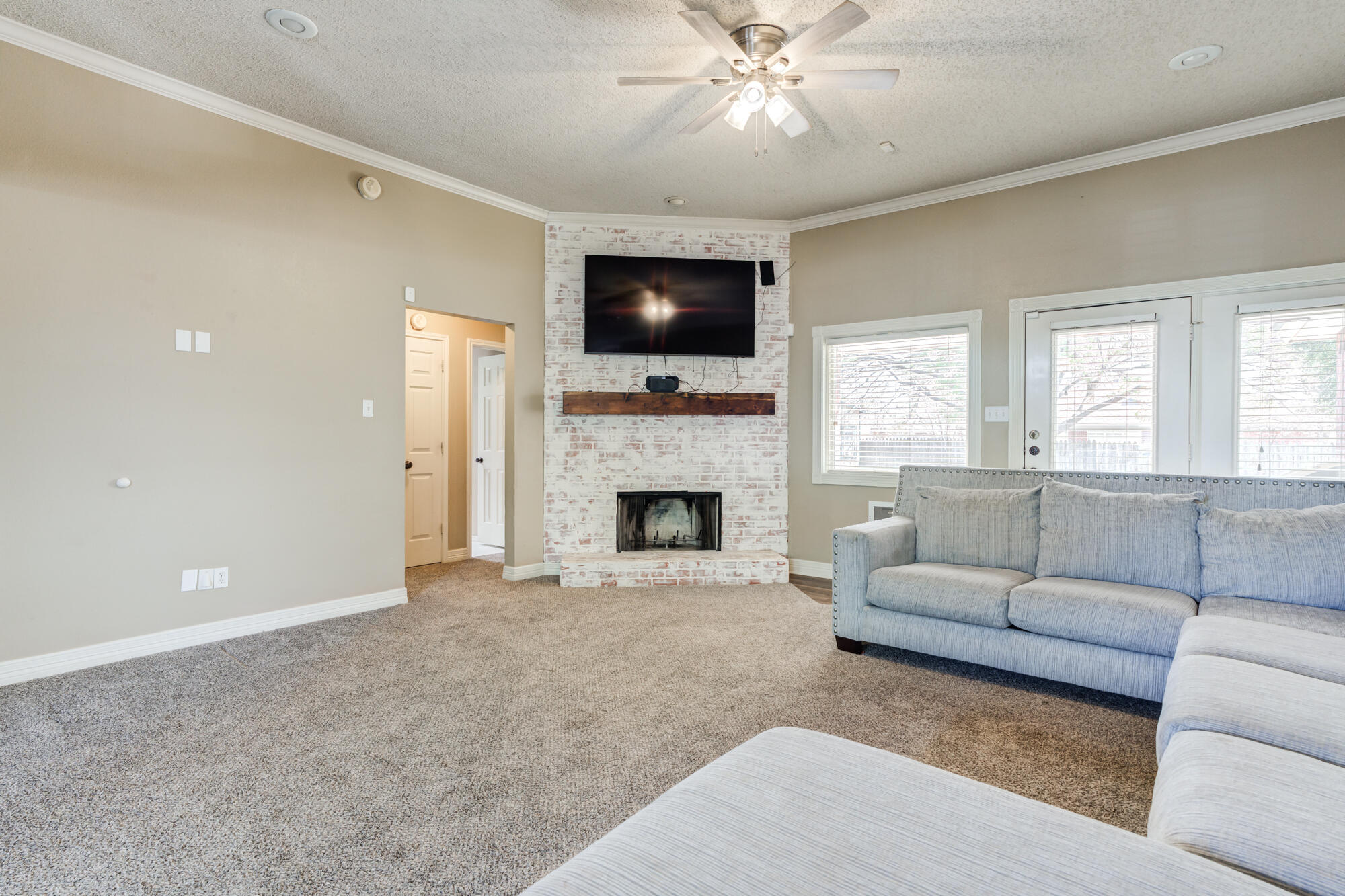 2807 87th Street Lubbock, TX 79423 - Photo 5 of 38 a living room with furniture a flat screen tv and a fireplace