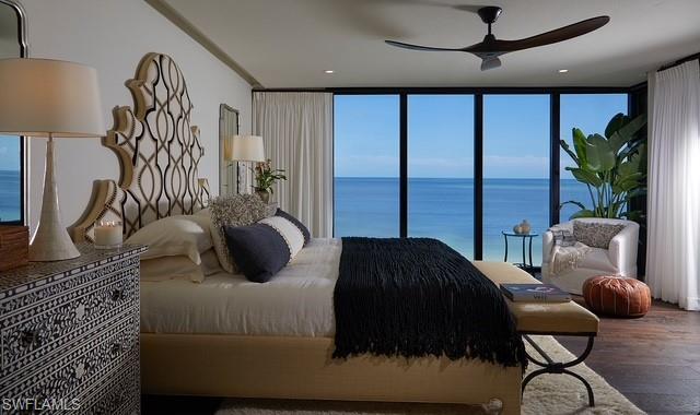 20 Seagate Drive, Unit 703 Naples, FL 34103 - Photo 6 of 19 a bedroom with a bed and ceiling fan