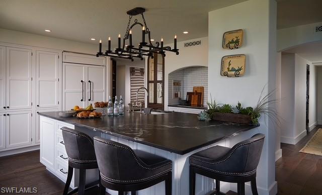 20 Seagate Drive, Unit 703 Naples, FL 34103 - Photo 7 of 19 a kitchen with stainless steel appliances granite countertop a dining table chairs and chandelier