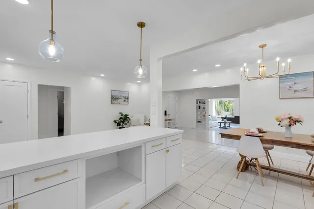 a room with stainless steel appliances kitchen island granite countertop furniture and a view of living room