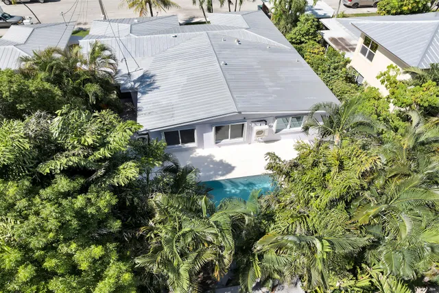 an aerial view of a house with a yard and garden in back